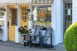 Ein Schaufenster mit einem Schild, auf dem 'ESPRESSO' steht, ein Fenster mit einem Logo und zwei Adirondack-Stühle davor.