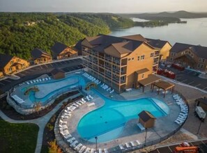 Ein Hotel mit großem Schwimmbad, mehreren Gebäuden und Seeblick.