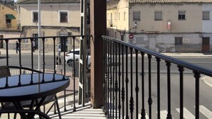 Uma varanda com mesa, vista da rua com edifícios e um letreiro 'Locker in the City'.
