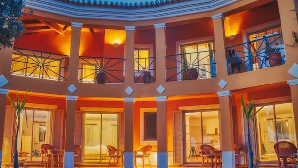 Un hotel de varios niveles con balcones, ventanas amplias y zonas de estar al aire libre.