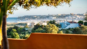 Un paisaje urbano costero con edificios, una playa y un acantilado.