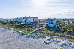 Een hotel aan de kust met meerdere gebouwen, een pad naar het strand en uitzicht op de oceaan.