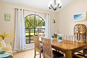 A dining area with a large window, a chandelier, and a view of the outdoors. - 833 Grandin Ave (Sebastian)