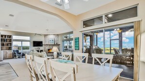 A spacious living room with a dining area, large windows, and a view of the outdoors. - 861 S Atlantic Ave (Cocoa Beach)
