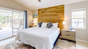 A bedroom with a bed, a wooden headboard, a ceiling fan, a nightstand, and a window. - 620 S Easy St (Sebastian)