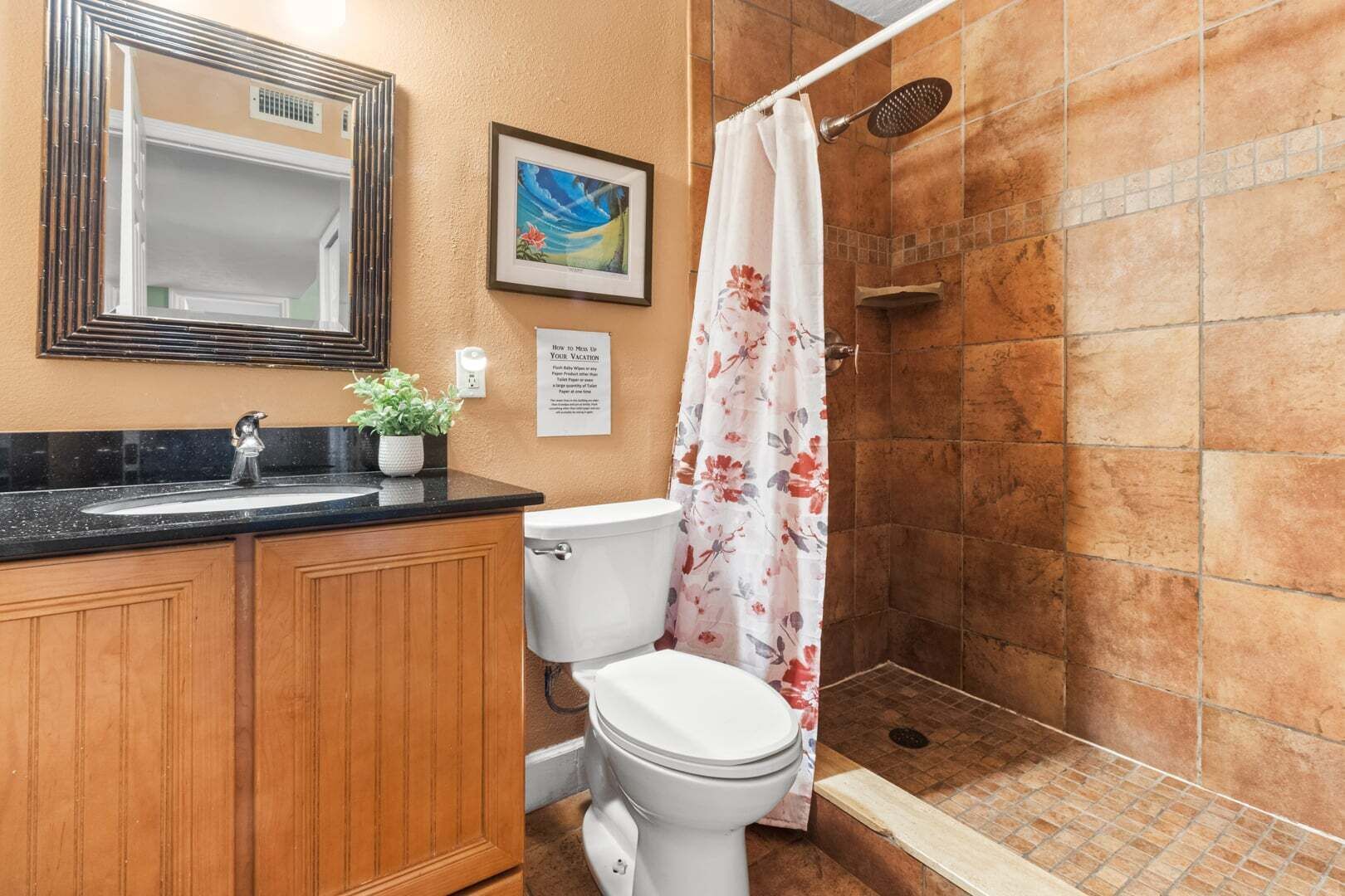 Une salle de bain équipée d’une douche, de toilettes, d’un lavabo et d’un miroir.
