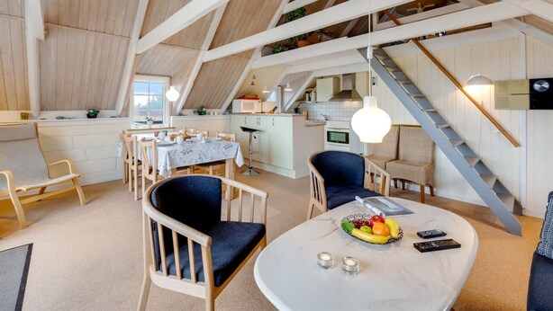 Un interior estilo loft, espacioso, con comedor, cocina y una escalera.