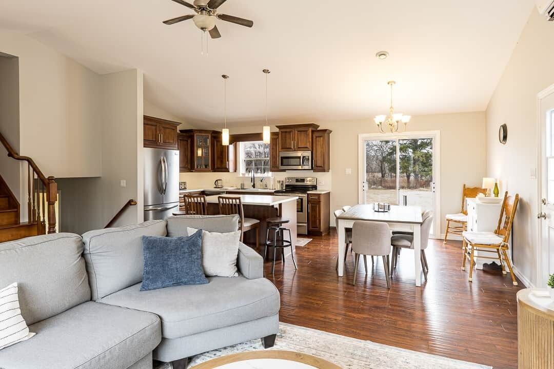 A spacious living area with a sofa, dining table, and kitchen in the background.