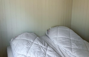 Two beds with white bedding against a paneled wall. - 3 bedroom nice home in Ringkøbing (Ringkøbing)