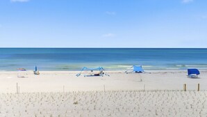 A beach with a sandy foreground, a clear blue sky, and a calm sea. - Amazing 1 bedroom with Gulf Views and Wraparound Balcony (Indian Shores)