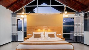 A bedroom with a large bed, wooden headboard, and a view of the mountains. - 3 Arch Resort - Ella (Ella)