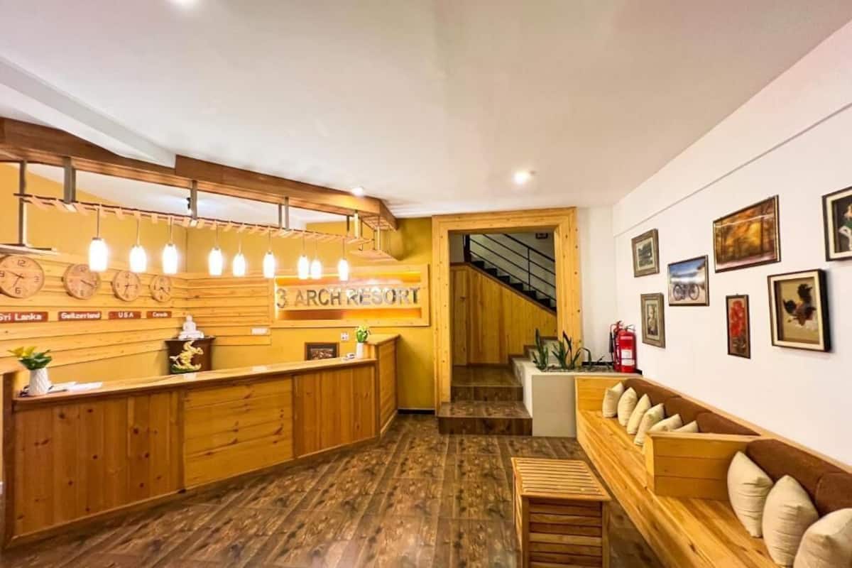 A reception area with a wooden counter, a staircase, and a wall with framed pictures.