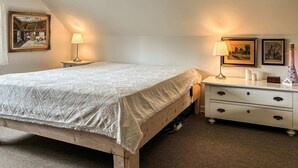 A bedroom with a bed, nightstand, dresser, and two wall-mounted lamps. - Stunning apartment in Holstebro with WiFi (Holstebro)
