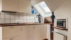 A kitchen with a skylight, a built-in microwave, and a coffee maker. - Stunning apartment in Holstebro with WiFi (Holstebro)