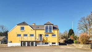 A two-story yellow building with a flat roof, a visible number '1915' on the facade, and a clear sky. - Stunning apartment in Holstebro with WiFi (Holstebro)