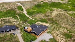 An aerial view of a coastal property with a large house, a smaller building, and a beach in the background. - "Mine" -  from the sea by Interhome (Hvide Sande)