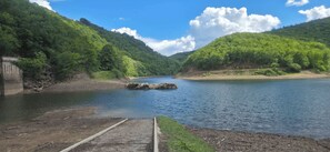 Une riviĂšre avec un barrage et des collines verdoyantes.