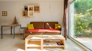 Sala de estar com sofá, mesa de centro e prateleiras.