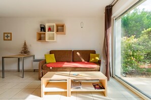A living room with a sofa, coffee table, and shelves. - Casa Jouarres - Appartement avec terrasse privée (Azille)