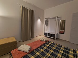 Ein Schlafzimmer mit Bett, Schrank, Spiegel und Nachttisch.
