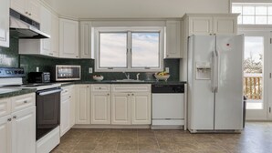 A kitchen with white cabinets, a microwave, a toaster, a sink, and a refrigerator. - Mountainview - Guest House by Avantstay Heated Pool + Hot Tub + Games Lake + Cannoe Near Hunter Mountain (Hensonville)