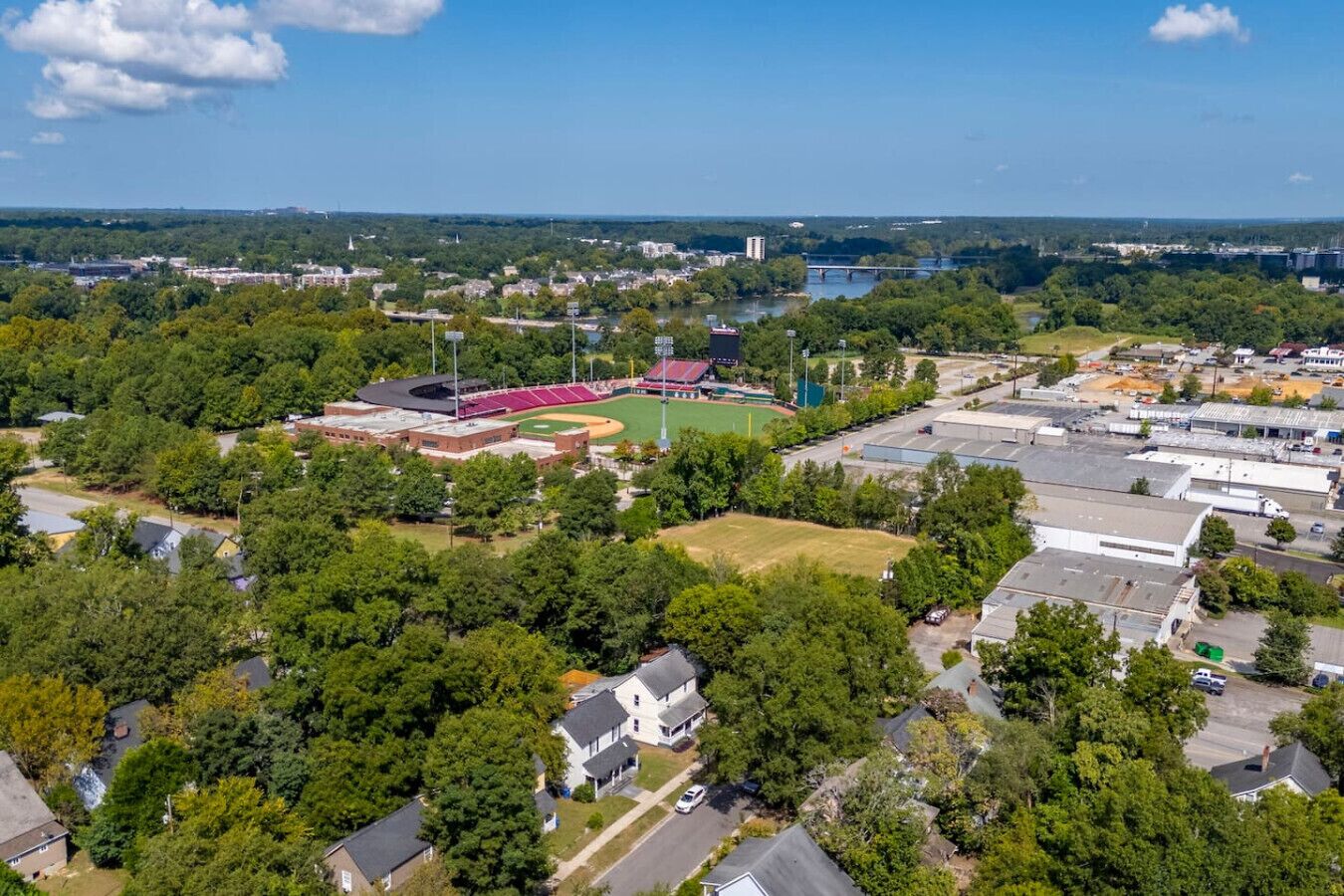 An aerial view of a residential area with houses, a baseball field, and industrial buildings.