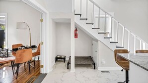 Un intérieur moderne comprenant un coin repas, un escalier et un espace dédié à l’alimentation des animaux de compagnie.