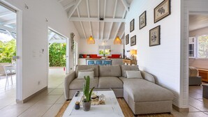 Sala de estar com sofá seccional, mesa de centro e cozinha ao fundo.