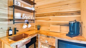 A wooden cabin interior with a kitchen area featuring a sink, a coffee maker, and shelves with dishes and a sign that says 'Live Laugh Love.' - Waterfront cabin-Couples getaway *Private hot tub* (Cherokee)