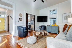 Ein Wohnzimmer mit einer Couch, einem Couchtisch, einem Fernseher und einem blauen Schrank.