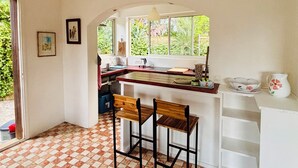 A kitchen with a checkered floor, a window, and a bar stool. - Family home sleeps 12, lush garden, sea view. Close to beaches. (Roquebrune-Cap-Martin)