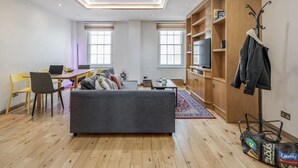 Una sala moderna con un sofá, una mesa de comedor y un televisor.