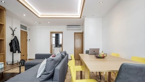 Una sala de estar moderna con un sofá, una mesa de comedor y sillas amarillas.