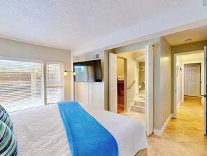 A bedroom with a bed, a closet, a bathroom, and a hallway leading to another room. - Del Mar Home with Rooftop Deck & Ocean Views (St. Augustine)