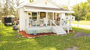 A white single-story house with a porch, a small front yard, and a mailbox. - Lovely 2-bedroom house with AC in charming Chipley. (Chipley)