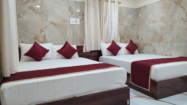 A hotel room with two beds, marble walls, and curtains. - SS Paradise Residency (Tiruvannamalai)