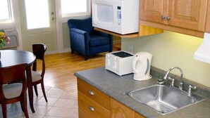 A compact kitchen with a microwave, toaster, coffee maker, and sink. - Island Sunset Resort (Belle Côte)