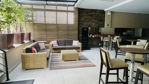 A modern lounge area with sofas, chairs, and a coffee table. - Apto 606 (Joinville)