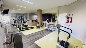 A gym with treadmills, ellipticals, and a stair climber. - Apto 606 (Joinville)