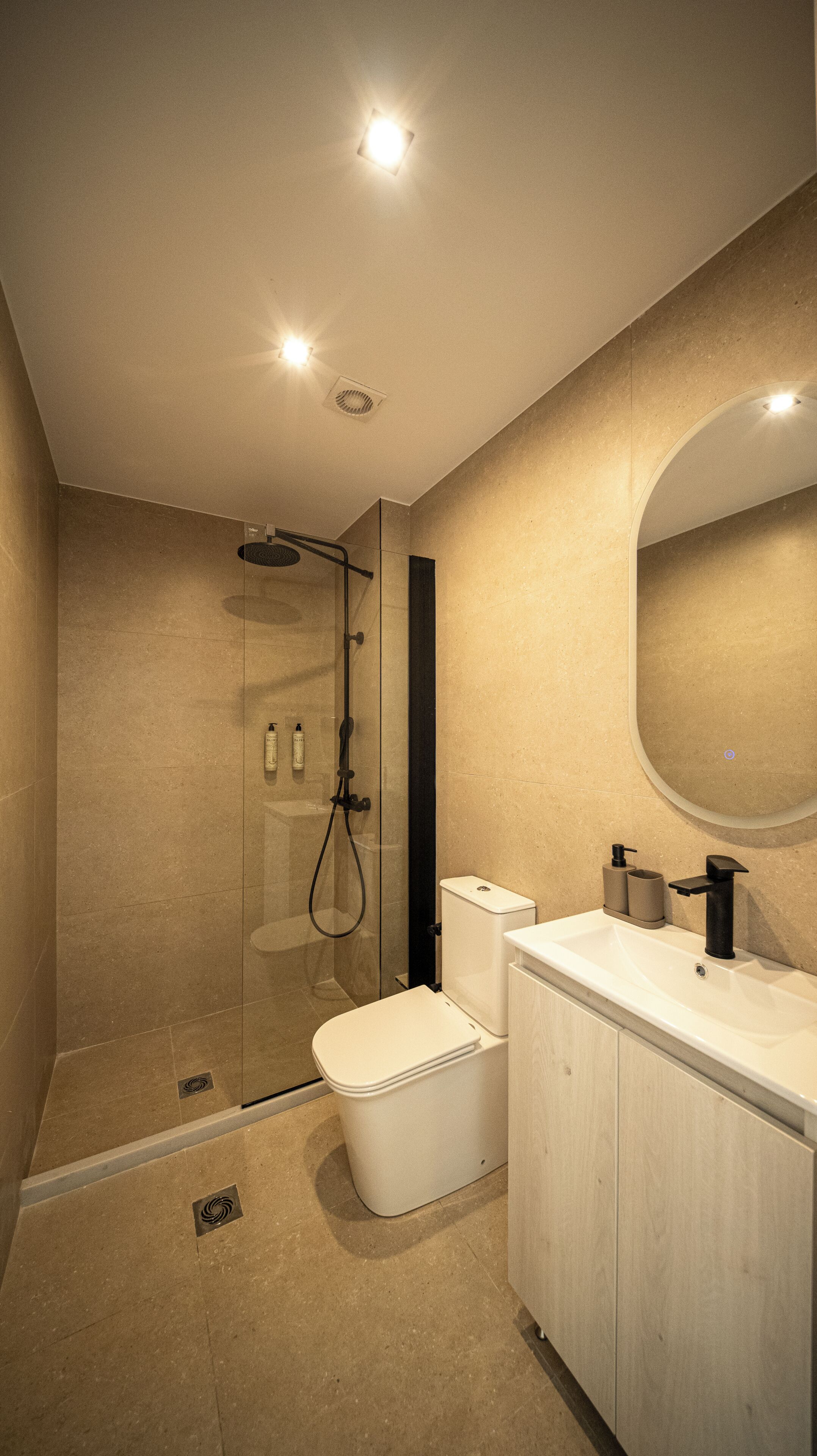 Une salle de bain moderne avec une douche à parois de verre, des toilettes et un lavabo avec un miroir.