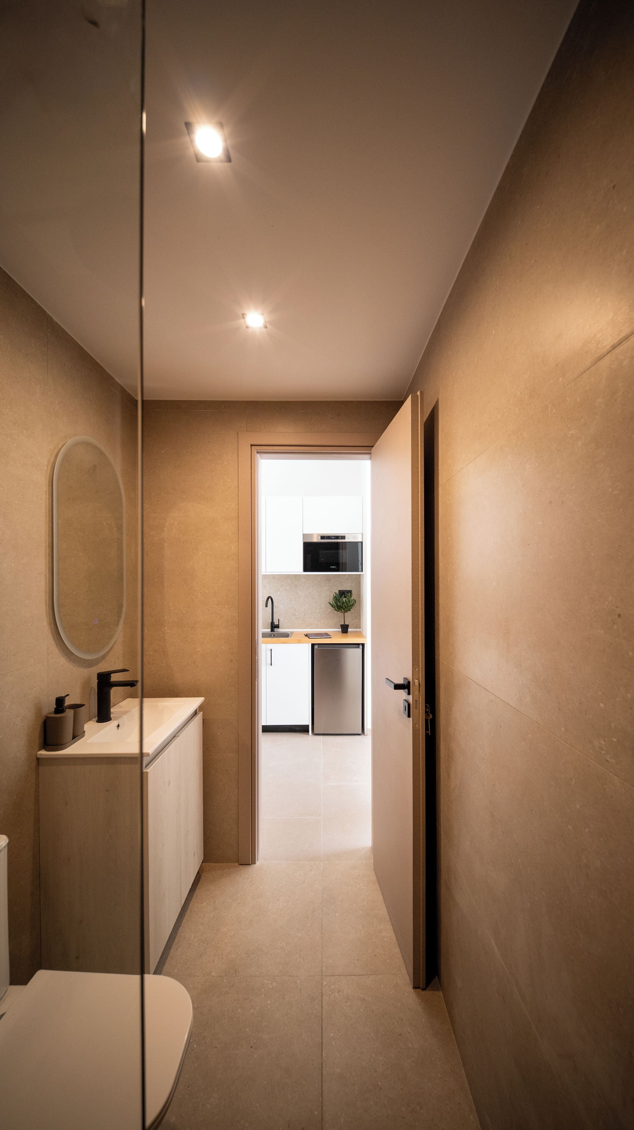 A modern bathroom with a toilet, sink, and mirror.