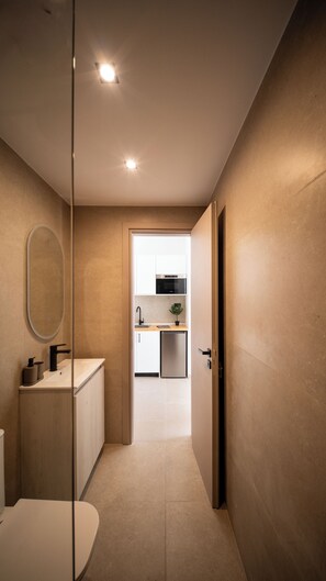 A modern bathroom with a toilet, sink, and mirror. - Ormos Piraeus (Piraeus)
