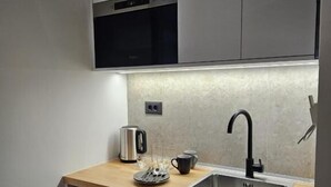 A modern kitchen with a stainless steel sink, a coffee maker, and a toaster. - Ormos Piraeus (Piraeus)