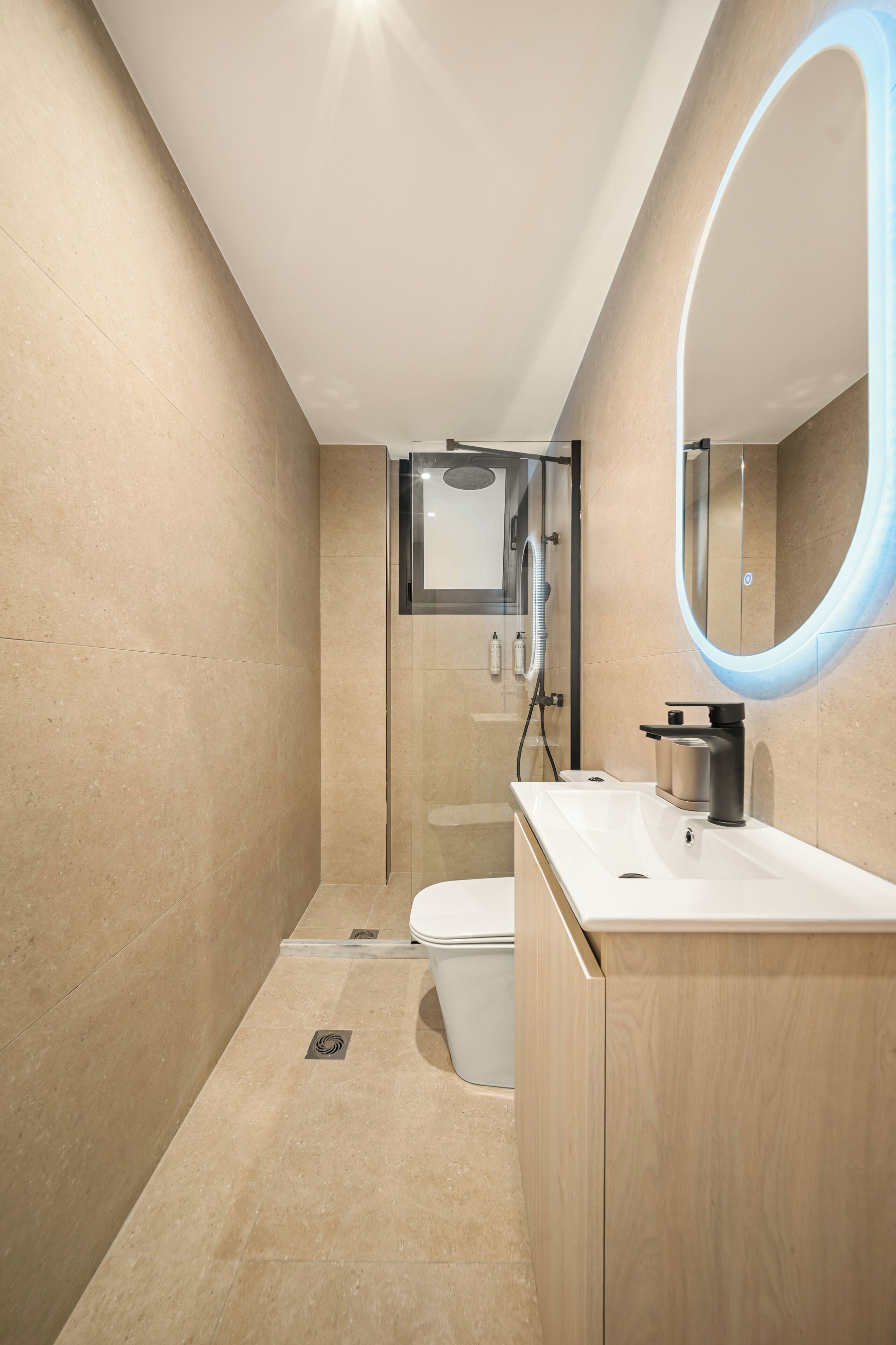 Een moderne badkamer met douche, toilet en wastafel.