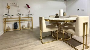 A dining area with a round table, chairs, and a gold-framed base. - OneLuxStay Coastal 2BR Near Beach (Torrance)