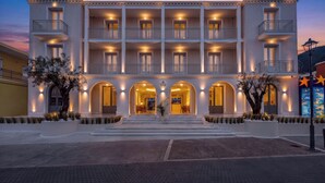 Un hotel de varios pisos con balcones, entradas arqueadas y una fachada bien iluminada.
