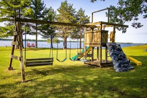 A playground with swings, a slide, and a climbing structure.