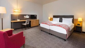 A hotel room with a bed, desk, chair, and two bedside lamps. - 4 Person Holiday Park Home in Neu-isenburg (Neu-Isenburg)