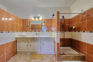 A bathroom with a shower, a sink, and a mirror.