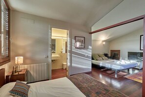 Un dormitorio con una cama, una mesita de noche, una lámpara, una ventana y vistas al baño.
